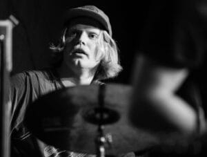 Svart/hvitt bilde av Axel Skalstad i aksjon bak trommesettet