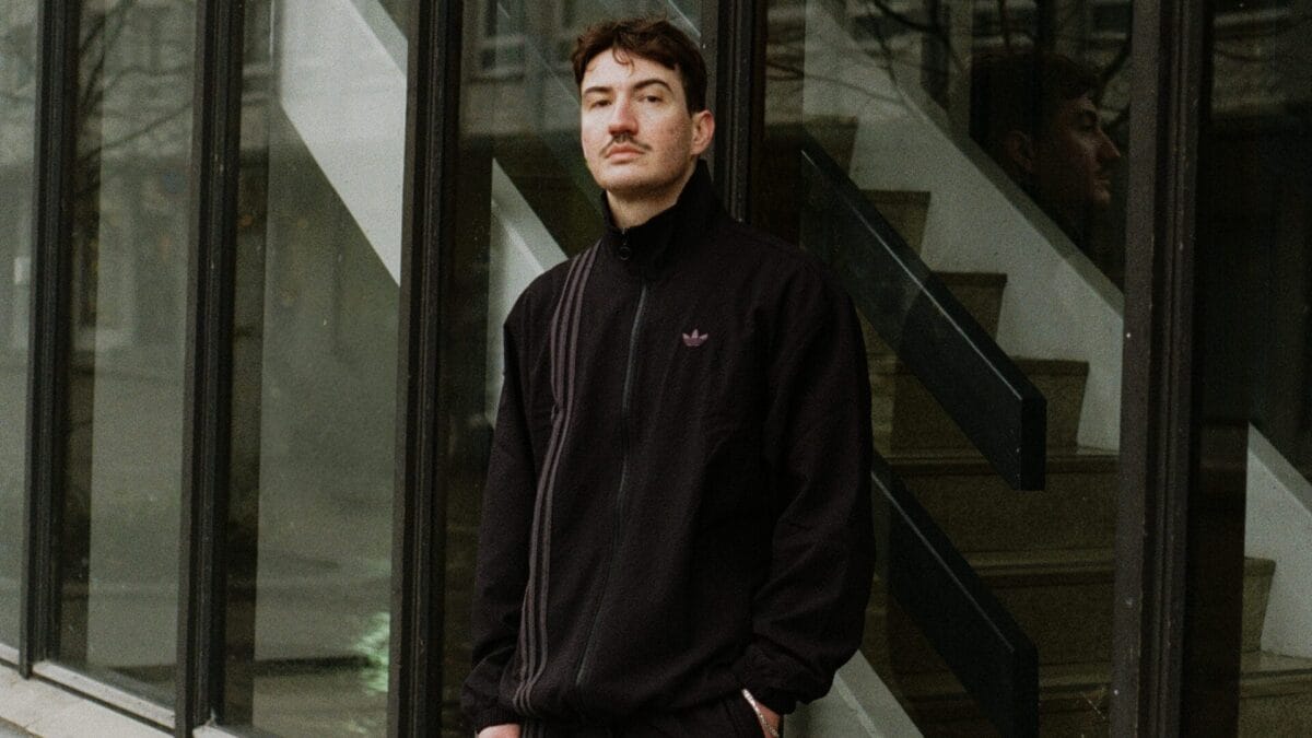 Bilde av Charlie Skien i adidas treningsdress utenfor en moderne bygning med store vinduer