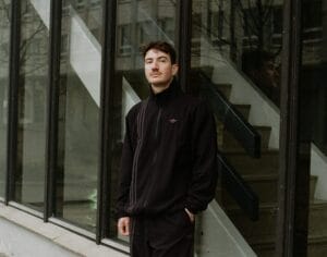 Bilde av Charlie Skien i adidas treningsdress utenfor en moderne bygning med store vinduer
