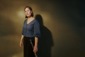 Artistbilde av Henriette Eilertsen i helfigur hvor hun holder en fløyte